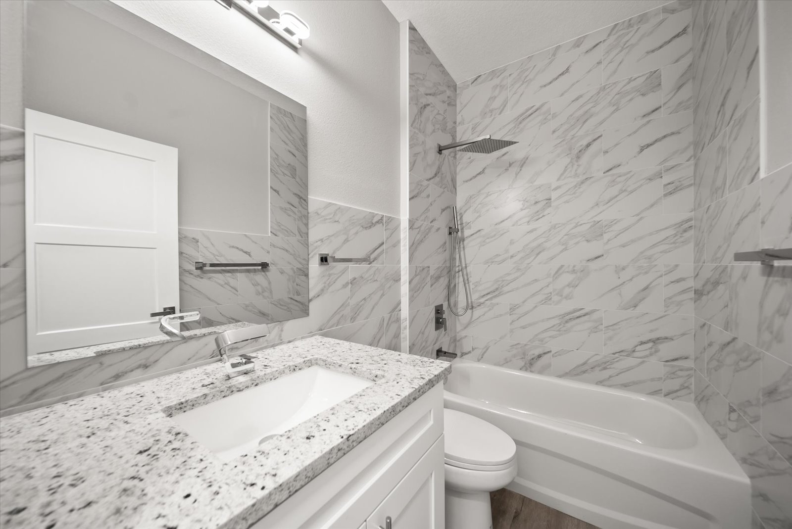 Bathroom vanity and tiled tub surround